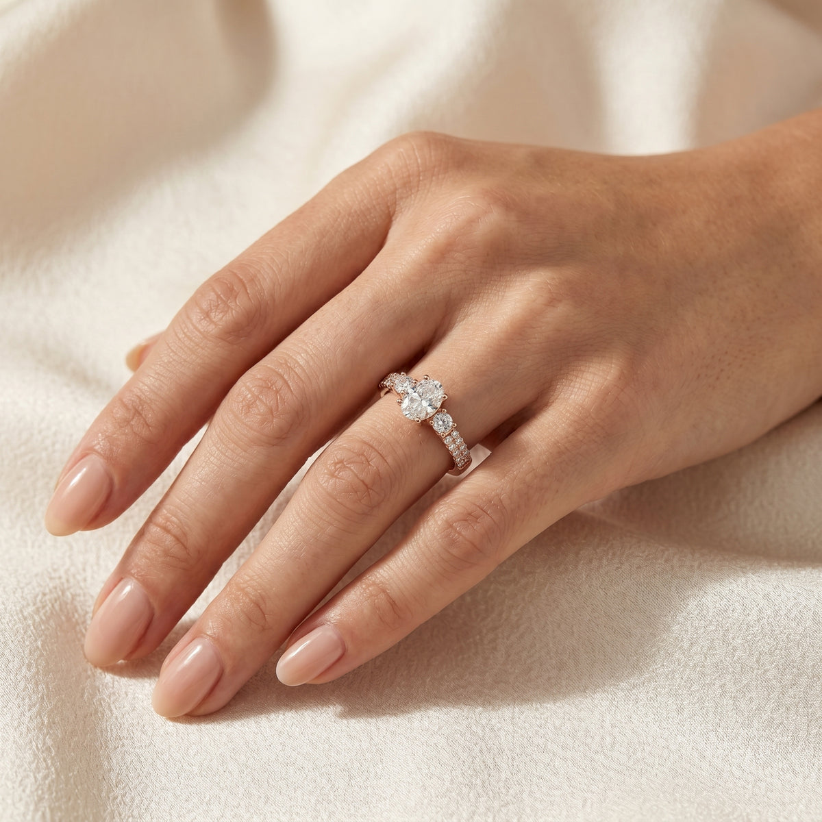 Oval Diamond Three Stone Engagement Ring with Round Sides and Pavé Band — lifestyle