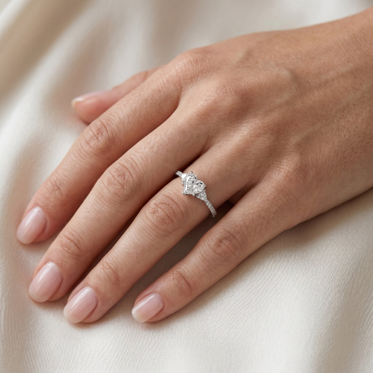 Heart Cut Three Stone Engagement Ring with Trilliant Sides and Pavé Band — lifestyle