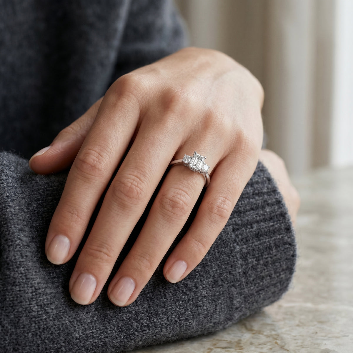 Emerald Cut Three Stone Engagement Ring with Round Sides — lifestyle